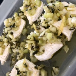 Fresh goat cheese with lemon and chives on a baking sheet can be enhanced by pairing it with Swiss wine tours for a private experience.