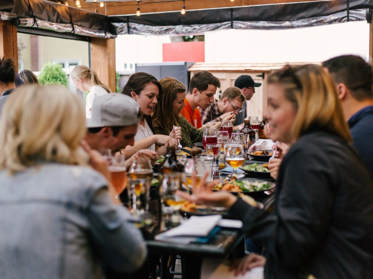 people sitting in front of table talking and eating